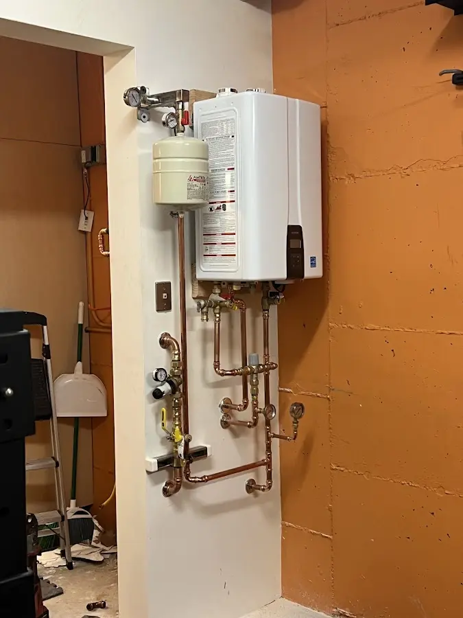 Plumbing technician inspecting water heater connections in Bristol